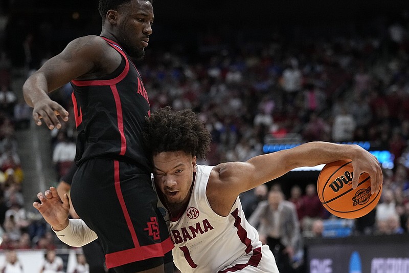 Alabama guard Mark Sears (1) runs into San Diego State guard Darrion Trammell during the first half of an NCAA Men’s Tournament South Region semifinal Friday in Louisville, Ky. The Aztecs knocked off the top-seeded Crimson Tide 71-64 to advance to the regional final Sunday.
(AP/John Bazemore)