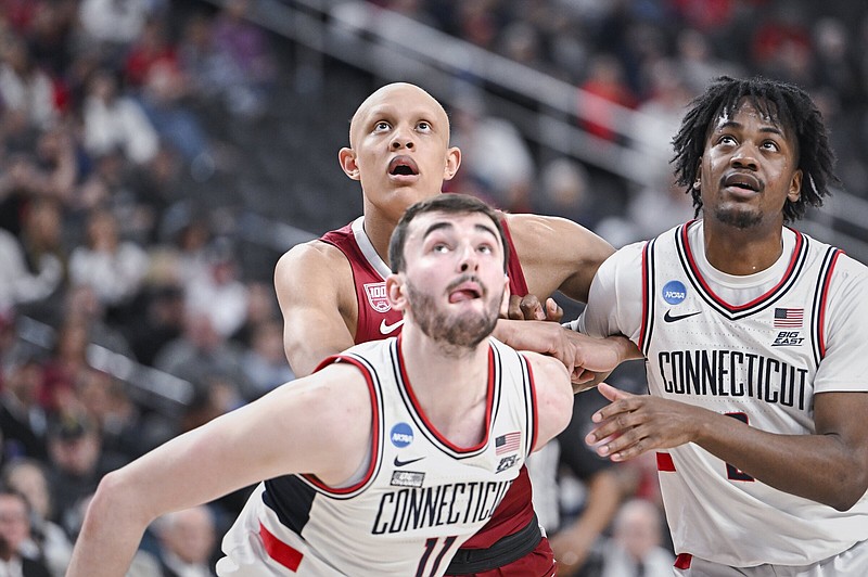 Arkansas forward Jordan Walsh (left) looks to rebound the ball along with Connecticut’s Alex Karaban (center) and Tristen Newton during Thursday’s NCAA Men’s Tournament game at T-Mobile Arena in Las Vegas. The Razorbacks were outrebounded 43-31 in an 88-65 loss.
(NWA Democrat-Gazette/Charlie Kaijo)