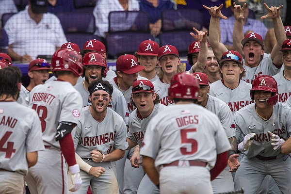 Arkansas pinch hitter Reese Robinett (18) is greeted by teammates after hitting a home run in the 10th inning of an NCAA college baseball game Friday, March 24, 2023, in Baton Rouge, La. ( Michael Johnson/The Advocate via AP)