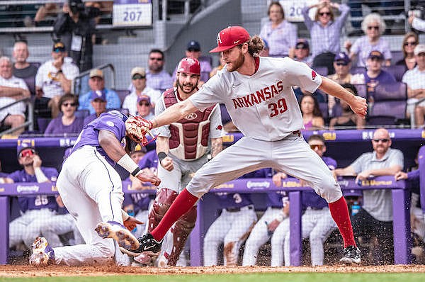 Arkansas pitcher Hunter Hollan (39) tags out LSU base runner Tre' Morgan at home plate during a game Friday, March 24, 2023, in Baton Rouge, La.