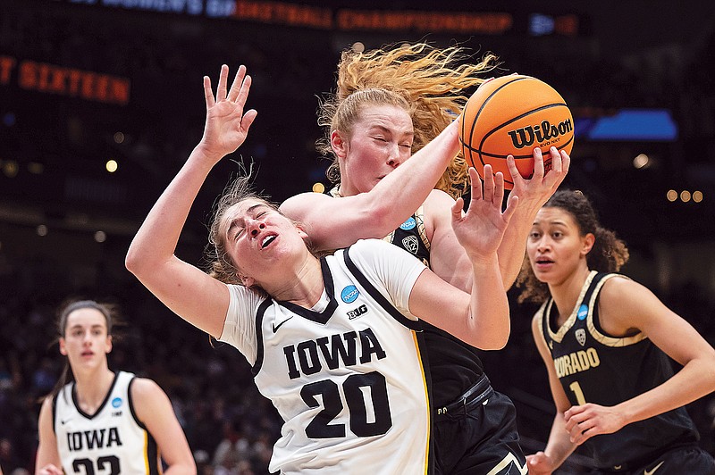 Colorado guard Frida Formann and Iowa guard Kate Martin compete for a rebound during Friday's regional semifinal game in the NCAA Tournament in Seattle. (Associated Press)