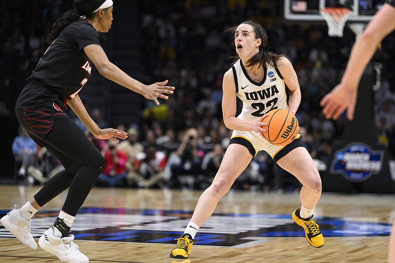 Iowa guard Caitlin Clark (22) steps back before shooting a 3-point basket as Louisville guard Morgan Jones (24) closes in on defense during the second quarter of a Sweet 16 college basketball game of the NCAA Tournament in Seattle, Sunday, March 26, 2023. (AP Photo/Caean Couto)