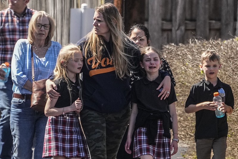 Children and a woman depart the reunification center at the Woodmont Baptist church after a school shooting, Monday, March 27, 2023, in Nashville, Tenn. (AP Photo/John Bazemore)