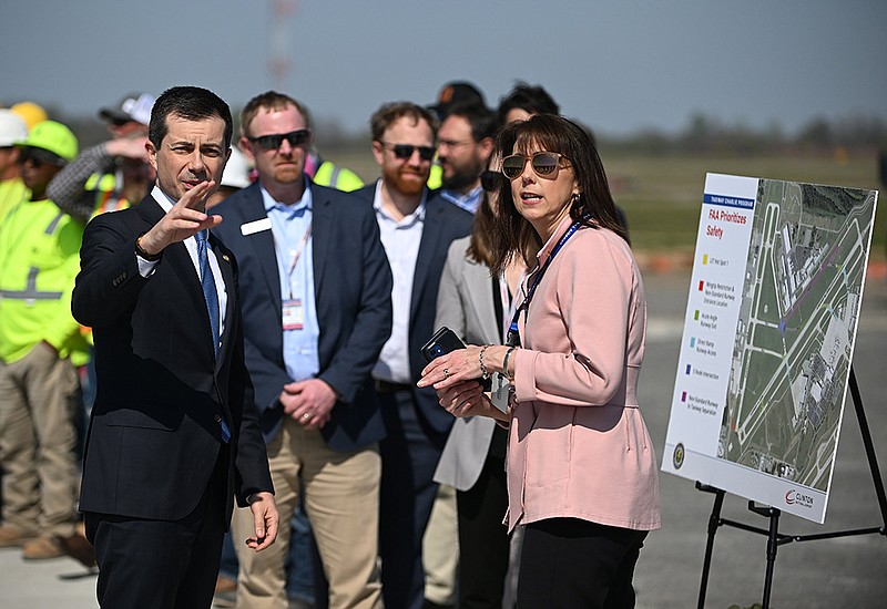 Secretary of Transportation Pete Buttigieg (left) talks with with Suzanne Peyton, director of properties, planning and development for the Bill and Hillary Clinton National Airport, during a tour of the Taxiway Charlie project on Wednesday.
(Arkansas Democrat-Gazette/Staci Vandagriff)