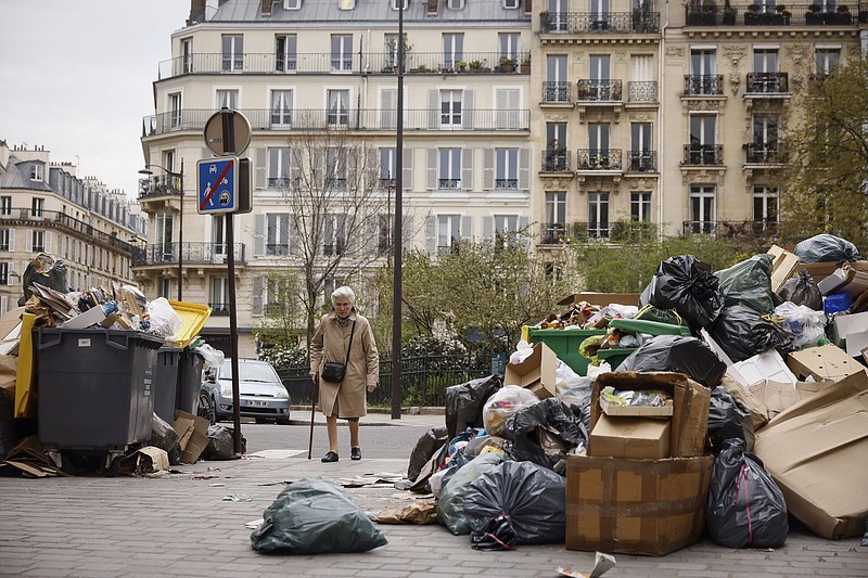 An elderly woman makes her way between uncollected garbage cans and bags Tuesday in Paris.
(AP/Thomas Padilla)