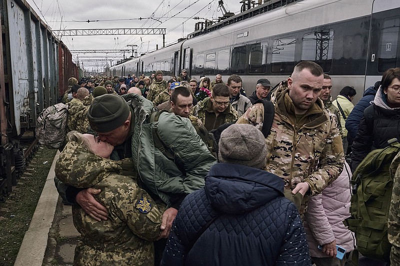 A Ukrainian woman soldier kisses her husband Wednesday as they meet at a railway station near the front lines at Kramatorsk in eastern Ukraine.
(AP/Libkos)