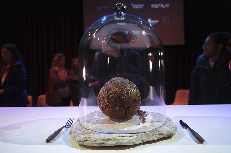 A meatball made using genetic code from a mammoth is seen at the Nemo science museum in Amsterdam, Tuesday March 28, 2023. An Australian company has lifted the glass cloche on a meatball made of lab-grown cultured meat using the genetic sequence from the long-extinct mastodon. The high-tech treat isn't available to eat yet - the startup says it is meant to fire up public debate about cultivated meat. (AP Photo/Mike Corder)
