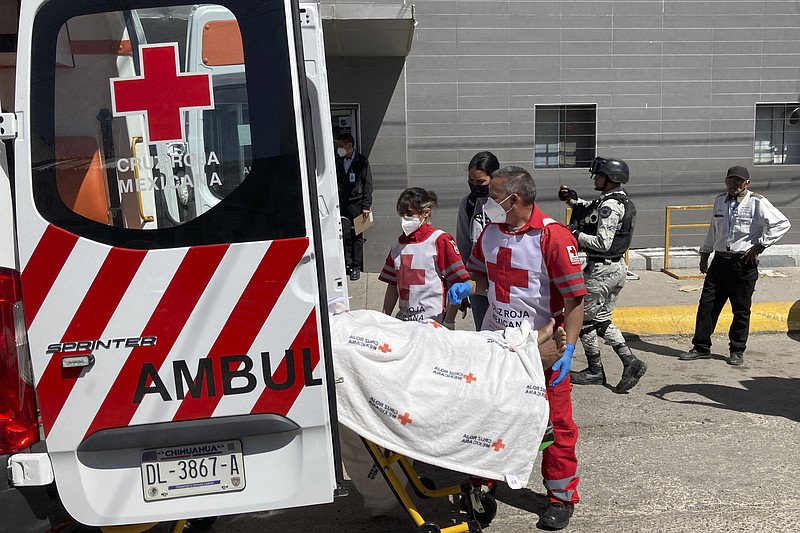 The Red Cross loads a patient, injured in a migrant detention center fire, into an ambulance, Tuesday, March 28, 2023, at a hospital in Cuidad Juarez, Mexico. According to Mexican President Andres Manuel Lopez Obrador, migrants fearing deportation set mattresses ablaze at the center, starting the fire that killed at least 40 migrants. (AP Photo/Morgan Lee)