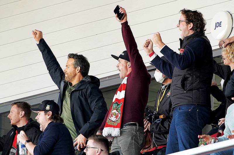 In this Oct. 30, 2021, file photo, Wrexham owners Ryan Reynolds (left) and Rob McElhenney celebrate after a goal during a game in Wrexham, England. (Associated Press)