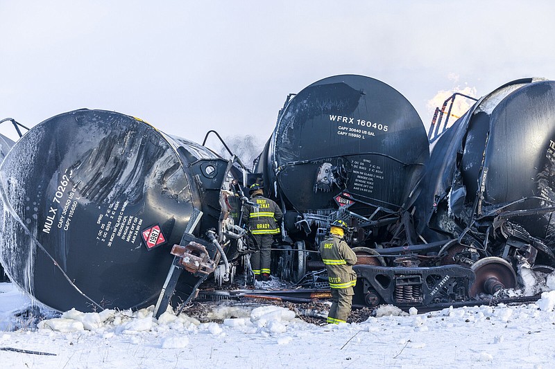 Firefighters work near piled up train cars, near Raymond, Minn., Thursday, the morning after a BNSF freight train derailed. Video at arkansasonline.com/331raymond/.
(AP/Minnesota Public Radio/Kerem Yücel)