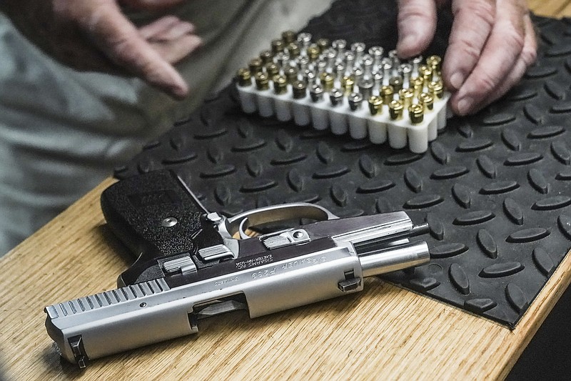 FILE - The owner of a shooting range, prepares to load bullets in his 9mm semi-automatic handgun for a demonstration, Thursday, June 23, 2022, in New York. (AP Photo/Bebeto Matthews, File)