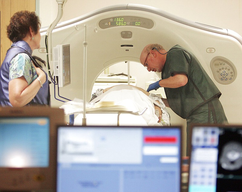 Dr. Steven Birnbaum works with a patient in a CT scanner to screen for cancer at Southern New Hampshire Medical Center in Nashua, N.H., in this June 3, 2010 file photo. (AP/Jim Cole)