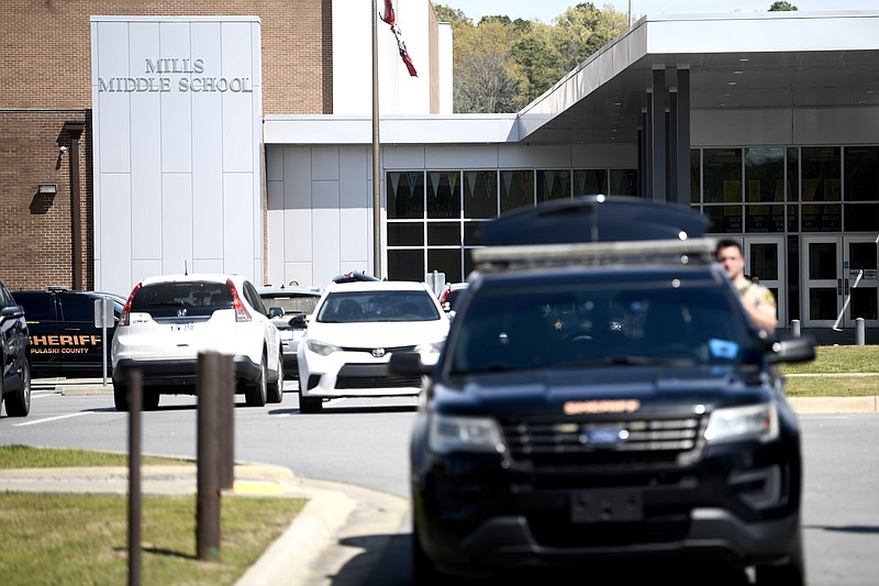 Law enforcement officers stand outside mills Middle School in Little Rock during a school-wide lockdown after calls threatening violence at the school on Thursday, March 30, 2023 (Arkansas Democrat-Gazette/Stephen Swofford)
