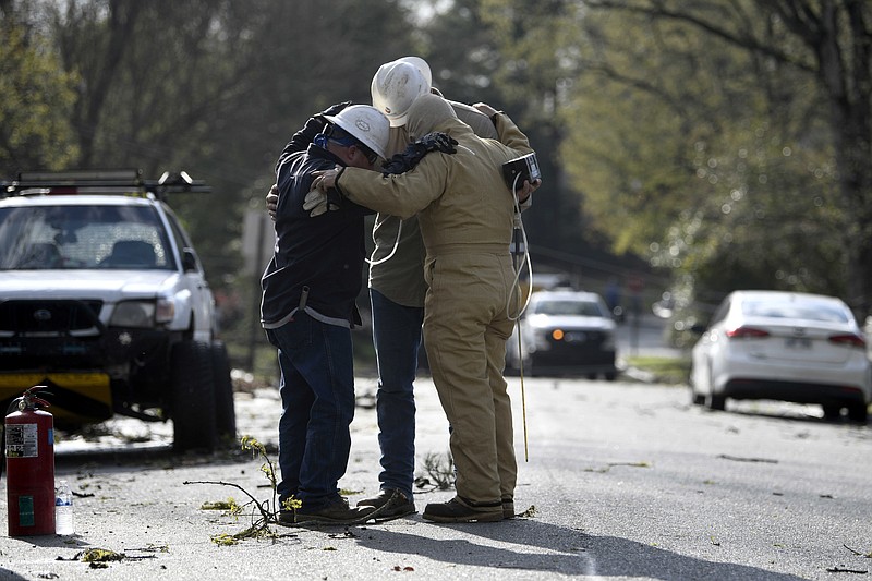 A team from Summit Energy say a prayer together before investigating a burst gas line in Cammack Village after a tornado swept through the area on Friday, March 31, 2023. See more photos at arkansasonline.com/41storm/..(Arkansas Democrat-Gazette/Stephen Swofford)