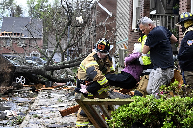 Firefighters carry a woman out of her condo in Little Rock after her complex was damaged by a tornado on Friday, March 31, 2023. See more photos at arkansasonline.com/41storm/..(Arkansas Democrat-Gazette/Stephen Swofford)
