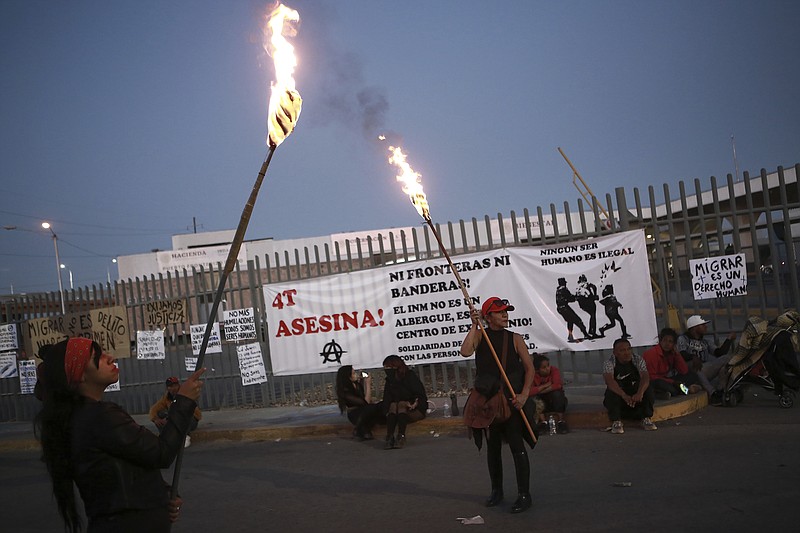 Activists protest outside a migrant detention center in Ciudad Juarez, Mexico, Wednesday, March 29, 2023, a day after dozens of migrants died in a fire at the center. (AP Photo/Christian Chavez)