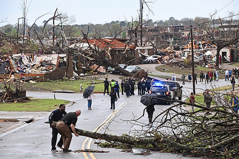 Police attempt to move large tree limbs out of the road after a tornado tore through west Little Rock on Friday, March 31, 2023..(Arkansas Democrat-Gazette/Staci Vandagriff)