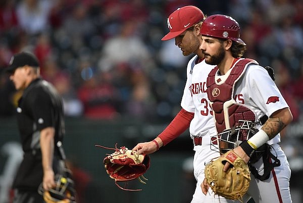 Arkansas pitcher Hunter Hollan returns to the dugout Friday, March 31, 2023, alongside catcher Parker Rowland during the fourth inning against Alabama at Baum-Walker Stadium in Fayetteville.