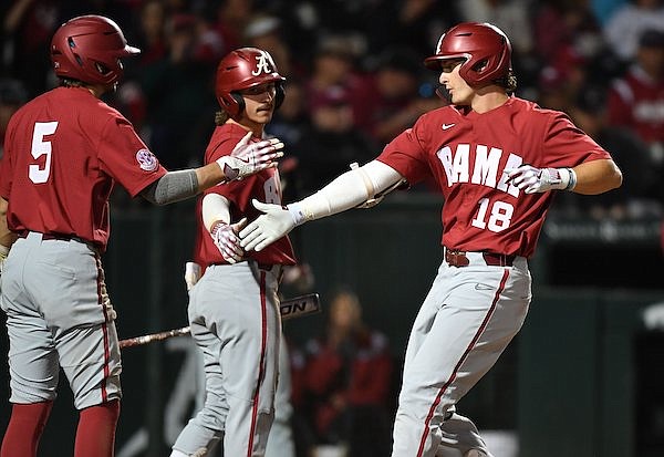 Alabama first baseman Drew Williamson (18) is congratulated at the plate Friday, March 31, 2023, by second baseman Ed Johnson (5) after hitting a two-run home run to score Johnson during the fifth inning against Arkansas at Baum-Walker Stadium in Fayetteville.