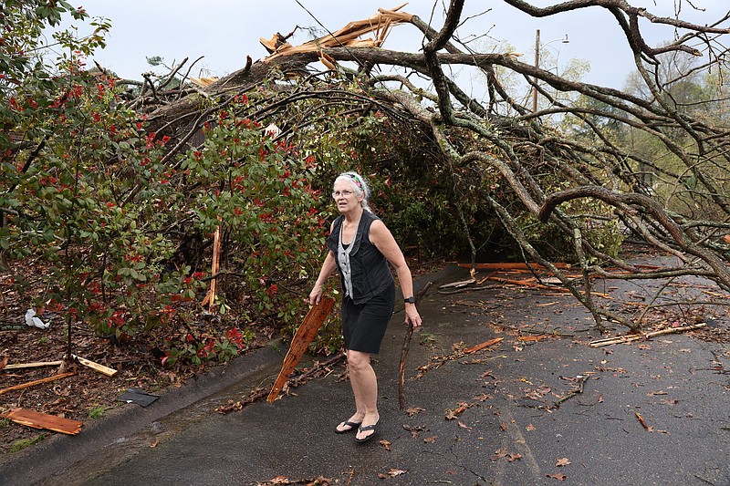 Cynthia Carlisi cleans up debris on Northgate Drive in Sherwood after a tornado caused extensive damage in the area Friday, March 31, 2023. (Arkansas Democrat-Gazette/Colin Murphey).