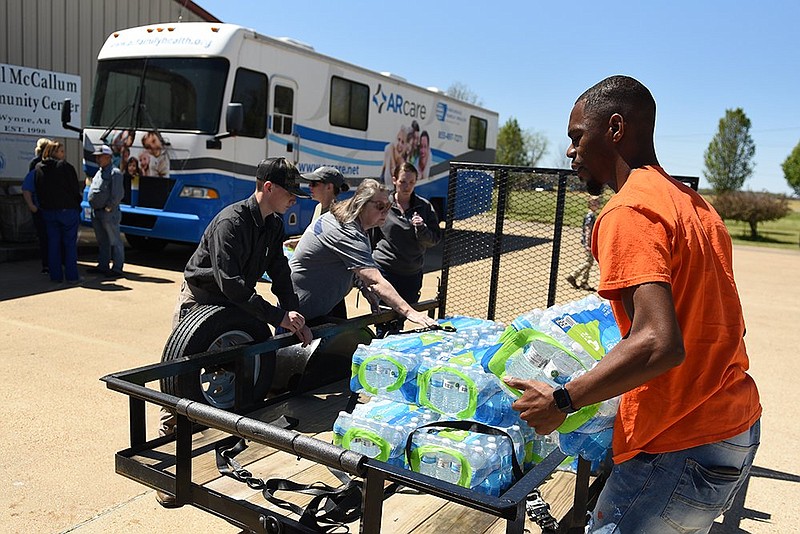 Eddie Elzy of Jonesboro helps unload cases of water Saturday, April 1, 2023 at the Odell McCallum Community Center in Wynne. (Arkansas Democrat-Gazette/Staci Vandagriff)