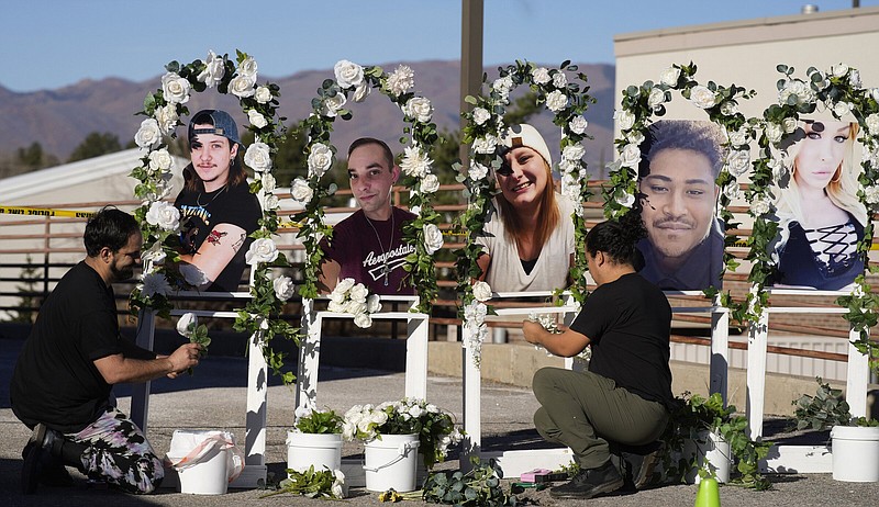 Noah Reich (left) and David Maldonado, the Los Angeles co-founders of Classroom of Compassion, put up a memorial Nov. 22, 2022, with photographs of the five victims of a mass shooting at a nearby gay nightclub in Colorado Springs, Colo.
(AP/David Zalubowski)