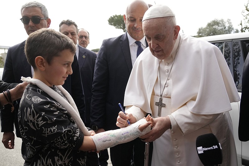 Pope Francis autographs the plaster cast of a child Saturday as he leaves the Agostino Gemelli University Hospital in Rome, after receiving treatment for bronchitis, the Vatican said.
(AP/Gregorio Borgia)