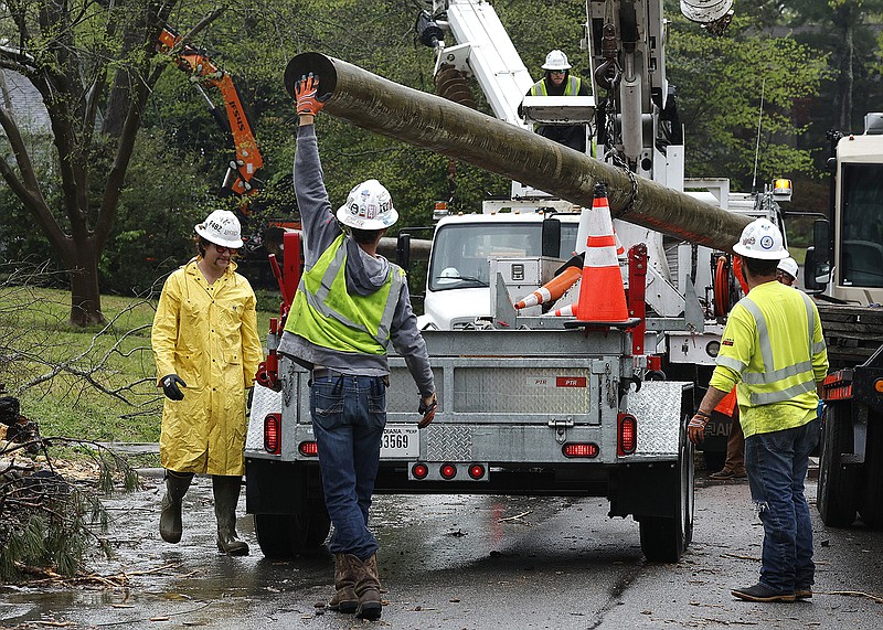 Workers with Bird Electric unload new power poles to be put up on Englewood Road in Little Rock on Wednesday.
(Arkansas Democrat-Gazette/Thomas Metthe)