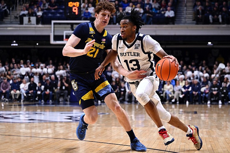 Butler guard Jayden Taylor (13) drives the ball around Marquette forward Ben Gold (21) during the first half of an NCAA basketball game, Tuesday, Feb. 28, 2023, in Indianapolis. (AP Photo/Marc Lebryk)
