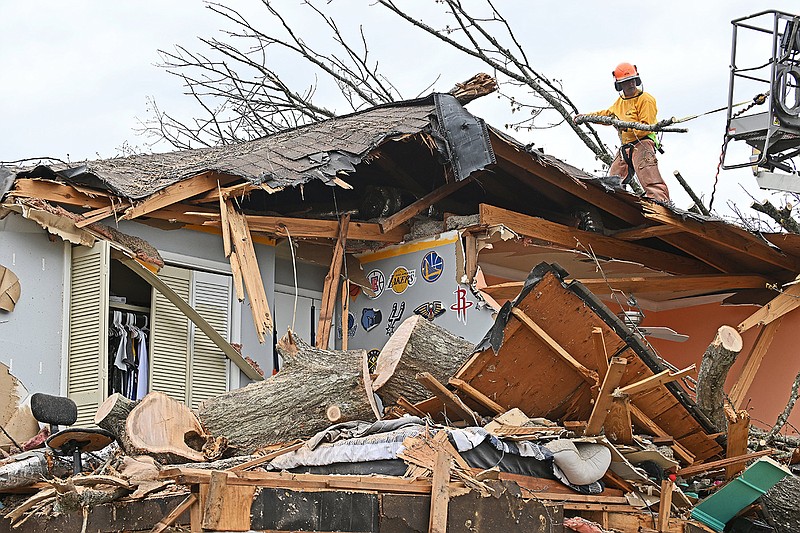Dan West of Arkansas Baptist Disaster Relief works Thursday afternoon to clear a fallen tree off a home in west Little Rock that was destroyed by the tornado.
(Arkansas Democrat-Gazette/Staci Vandagriff)