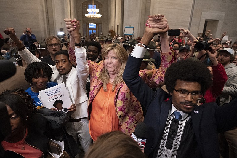 Former Rep. Justin Jones, D-Nashville, Rep. Gloria Johnson, D-Knoxville, and former Rep. Justin Pearson, D-Memphis, raises their hands outside the House chamber after Jones and Pearson were expelled from the legislature Thursday, April 6, 2023, in Nashville, Tenn.  (AP Photo/George Walker IV)