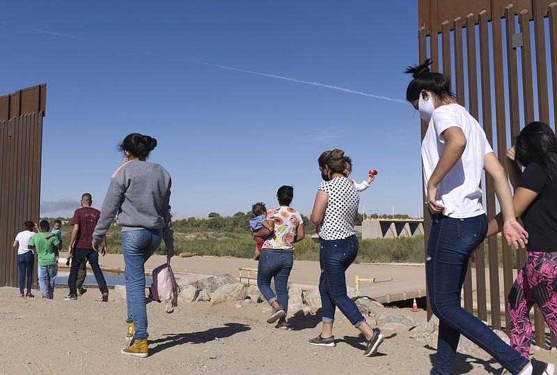 FILE - A group of Brazilian migrants make their way around a gap in the U.S.-Mexico border in Yuma, Ariz., seeking asylum in the U.S. after crossing over from Mexico, June 8, 2021. (AP Photo/Eugene Garcia, File)