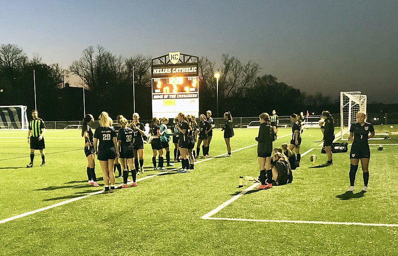 The Helias Lady Crusaders converge near the sideline during a break in play Wednesday night against the Father Tolton Lady Trailblazers at the Crusader Athletic Complex. (Tom Rackers/News Tribune)