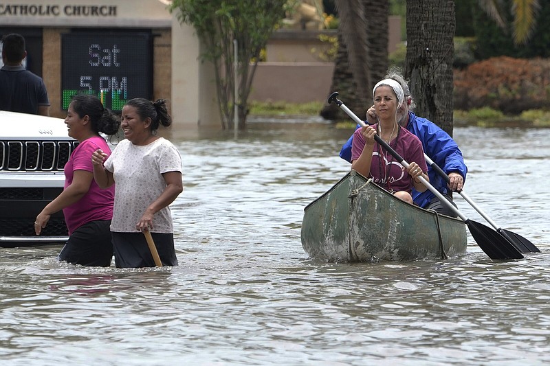 Residents paddle and walk along a flooded road Thursday in Fort Lauderdale, Fla. More photos at arkansasonline.com/414southfla/.
(AP/Marta Lavandier)