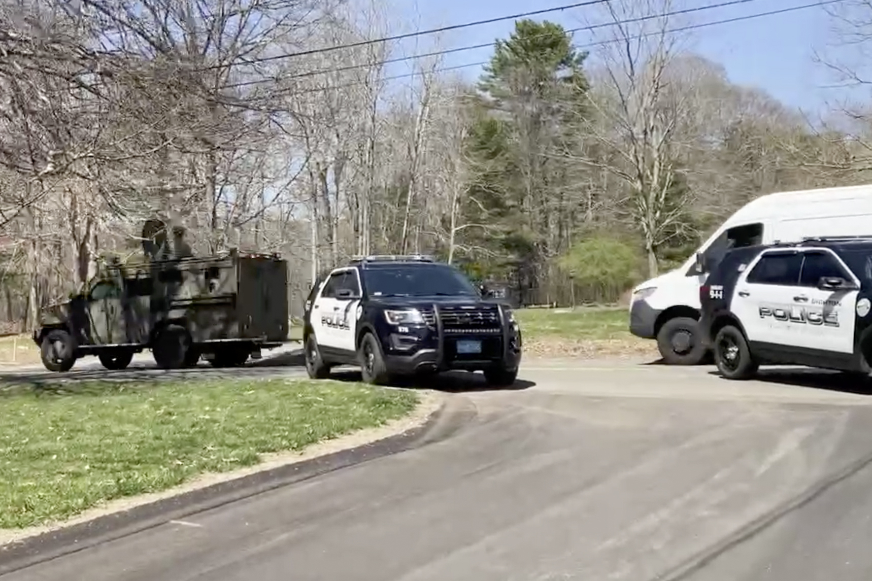 In this image taken from video, police block a road in North Dighton, Mass., Thursday, April 13, 2023. The FBI wants to question a 21-year-old member of the Massachusetts Air National Guard in connection with the disclosure of highly classified military documents on the Ukraine war, two people familiar with the investigation said. (AP Photo/Michelle R. Smith)