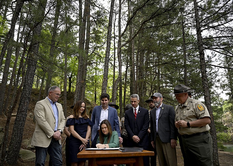 Gov. Sarah Huckabee Sanders signs several bills intended to encourage tourism to Arkansas parks during a signing at Pinnacle Mountain State Park near Little Rock on Thursday.
(Arkansas Democrat-Gazette/Stephen Swofford)