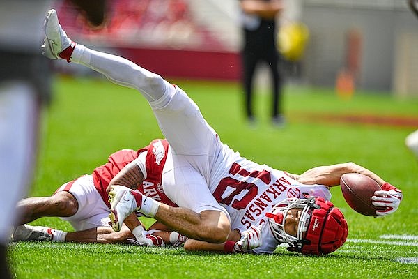 Arkansas wide receiver Isaiah Sategna (16) is tackled by defensive back Courtney Snelling (31), Saturday, April 15, 2023, during the Red-White Spring Football Showcase at Donald W. Reynolds Razorback Stadium in Fayetteville.
