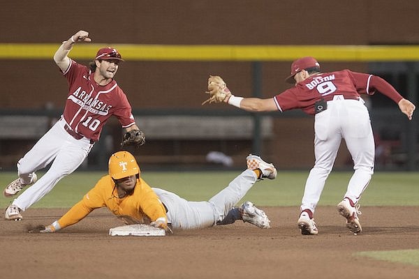 Arkansas' Peyton Stovall (10) celebrates after John Bolton (9) completes a double play by tagging Tennessee's Kavares Tears at second base during a game Saturday, April 15, 2023, in Fayetteville.
