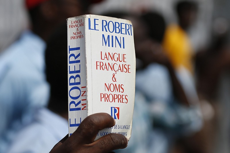 A man carries a paperback French dictionary in this Oct. 21, 2019 file photo. (AP/Rebecca Blackwell)