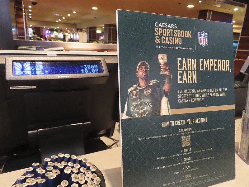 A sign bearing an advertisement for Caesars Entertainment's sports betting operation is displayed near a sports betting terminal in the sports betting lounge at the Tropicana casino in Atlantic City, N.J., May 12, 2022. Caesars is one of the most frequent advertisers of sports betting in the United States. Most of the nation's major professional sports leagues, plus the FOX media company are creating an alliance to ensure that sports betting advertising is done responsibly and does not target minors, it was announced Wednesday, April 19, 2023. (AP Photo/Wayne Parry)