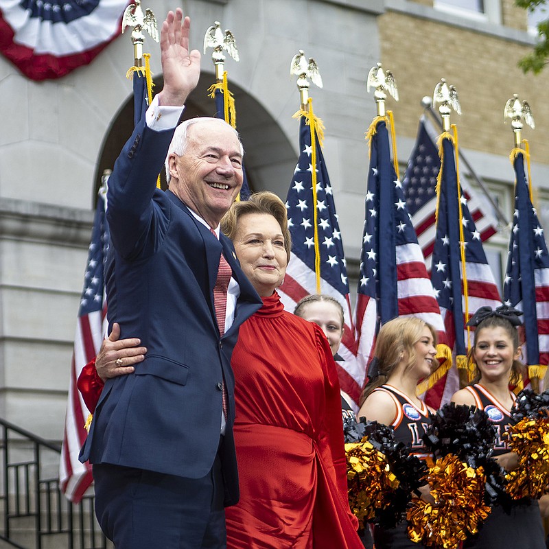 Former Gov. Asa Hutchinson and his wife, Susan, wave to supporters Wednesday from the steps of the Benton County Courthouse in Bentonville’s town square as he officially enters the presidential race. More photos at arkansasonline.com/427Asa/.
(NWA Democrat-Gazette/Charlie Kaijo)