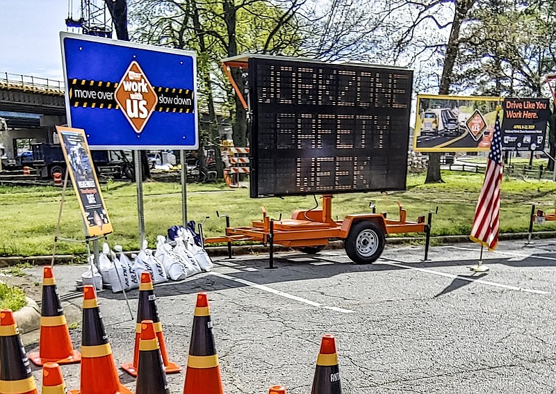 Signs used to warn Arkansas drivers of work zones are shown in this April 2019 file photo. In the foreground are traffic cones representing Arkansas Department of Transportation employees killed in work-zone crashes. (Arkansas Democrat-Gazette file photo)