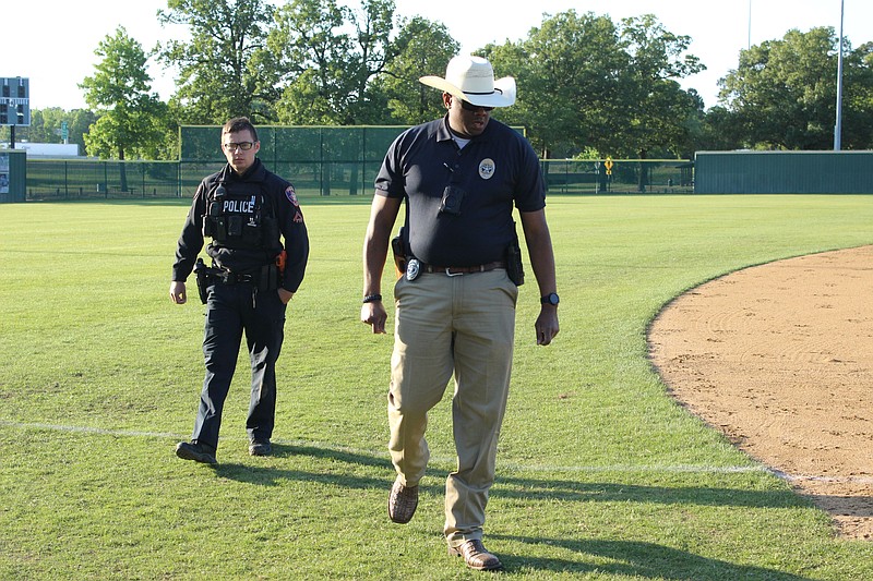 Officer Cole Bredenberg, left, and Detective Alan Bailey of Texarkana Texas Police Department scour George Dobson Field for evidence after a Texas A&M University-Texarkana baseball player was hit by a stray bullet Saturday evening, April 29, 2023, at Spring Lake Park. The 18-year-old player underwent emergency surgery at a local hospital. (Staff photo by Stevon Gamble)