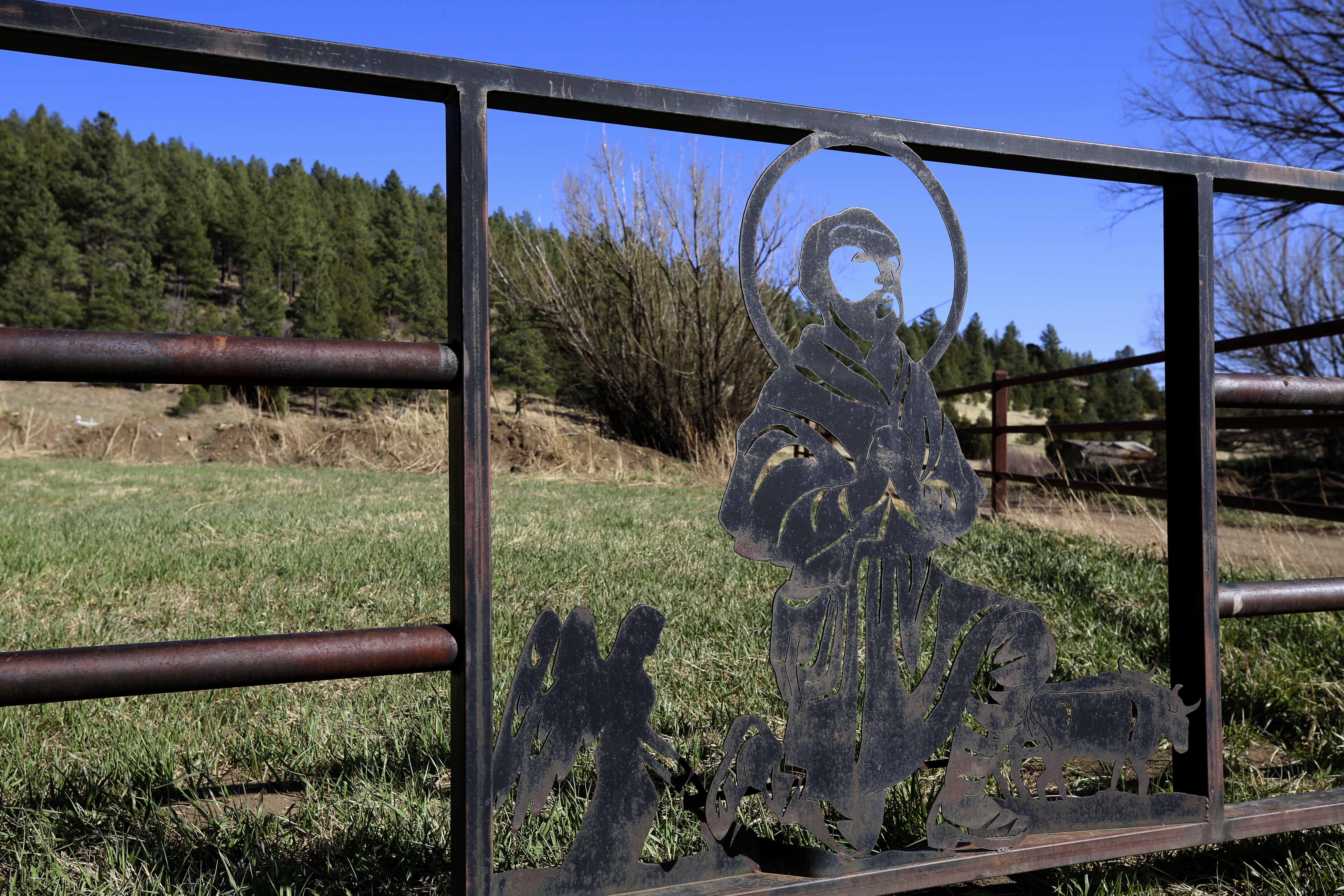 An image of San Isidro, patron saint of farmers, is sculpted in the metal gate outside the chapel dedicated to the Catholic saint near the hamlet of Holman, New Mexico, Saturday, April 15, 2023. The chapel or