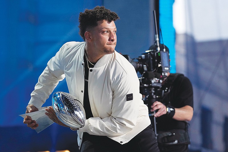 Chiefs quarterback Patrick Mahomes pretends to throw the Vince Lombardi Trophy during Thursday night's first round of the NFL Draft in Kansas City. (Associated Press)