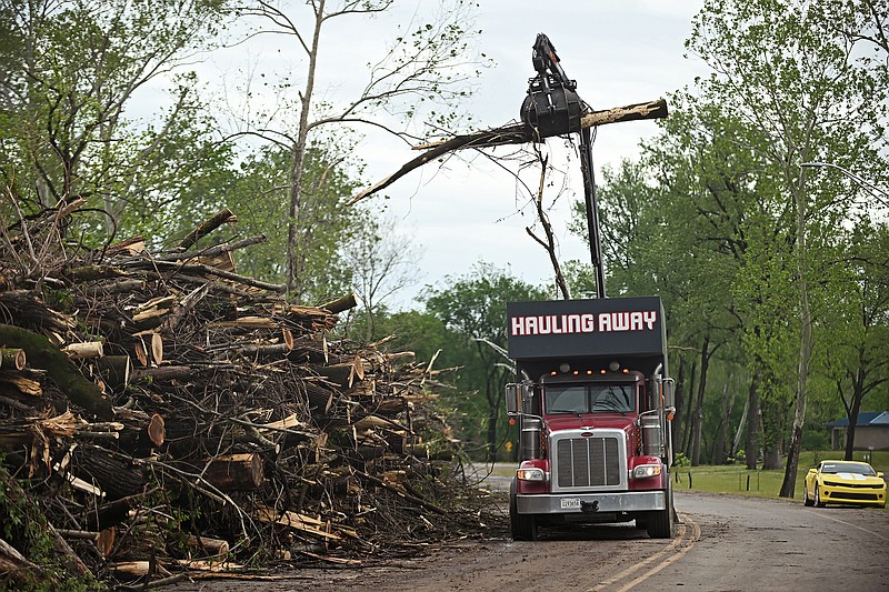A heavy machinery operator works Wednesday, April 26, 2023 to move large parts of trees that were damaged by the March 31 tornado that tore through Burns Park in North Little Rock..(Arkansas Democrat-Gazette/Staci Vandagriff)