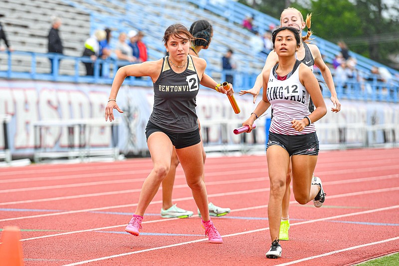 Bentonville’s Madison Galindo (left) accepts the baton from teammate Devyn O’Daniel during the girls’ 3,200-meter relay Thursday in the Class 6A state track and field meet at Jim Rowland Stadium in Fort Smith. Bentonville’s relay team of Galindo, O’Daniel, Allison Fernstrom and Hannah Hanson won the event.
(NWA Democrat-Gazette/Hank Layton)