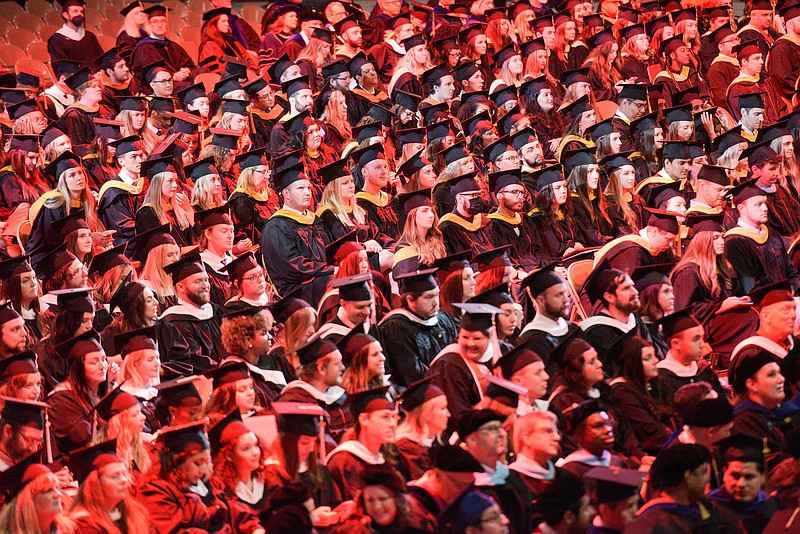 Students watch on Saturday, May 14, 2022, as fellow graduates receive their degrees at the University of Arkansas' main commencement ceremony inside Bud Walton Arena in Fayetteville.  (NWA Democrat-Gazette/Hank Layton)