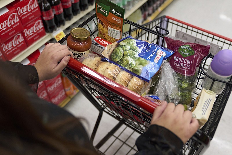 File - A cart holding groceries is pushed through a supermarket in Bellflower, Calif., on Monday, Feb. 13, 2023. (AP Photo/Allison Dinner, File)