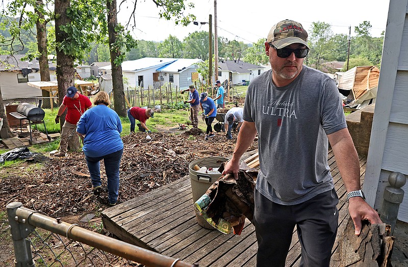 Jeff Jackson with the Golden Eagle volunteer group, far right, removes debris from the March 31 tornado from the backyard of a home on Oakview Drive in North Little Rock on Saturday, May 13, 2023. (Arkansas Democrat-Gazette/Colin Murphey)